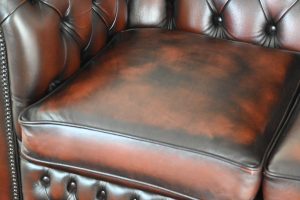 Tijdloze 2-zits Chesterfield met zacht geveerde vloerkleed en elegant design.