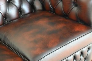 Tijdloze 2-zits Chesterfield met zacht geveerde vloerkleed en elegant design.