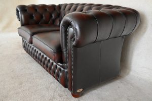 Tijdloze 2-zits Chesterfield met zacht geveerde vloerkleed en elegant design.