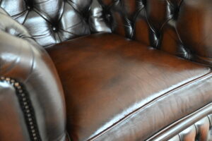 Stijlvolle traditionele bruine Chesterfield Lowback-chair met stevige rug en medium zit. Topoccasion met garantie. Duurzaam en circulair alternatief.